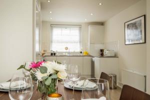 a dining room table with a vase of flowers on it at Covent Garden Maisonette in London