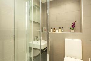 a white bathroom with a sink and a shower at Covent Garden Maisonette in London