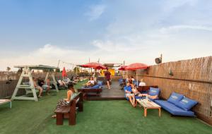 
a patio area with tables, chairs and umbrellas at Abraham Hostel Jerusalem in Jerusalem
