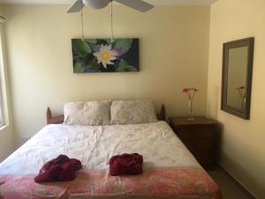 een slaapkamer met een bed met twee rode badjassen erop bij Absolute Beachfront Villa in Ko Chang