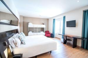 une chambre d'hôtel avec un lit et un bureau dans l'établissement Petit Palace Plaza de la Reina, à Valence
