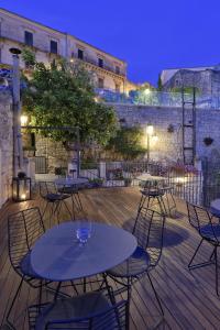 a group of tables and chairs on a deck at night at Edel Modica in Modica