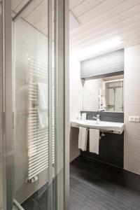 uma casa de banho com um lavatório e um espelho em Hotel Oberland em Lauterbrunnen