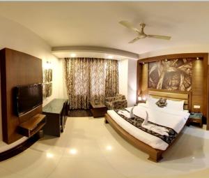 a bedroom with a large bed and a flat screen tv at Namaskar Residency in Amritsar