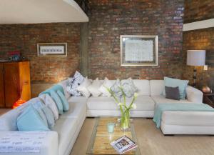 a living room with a white couch and a brick wall at Waterkant Loft in Cape Town