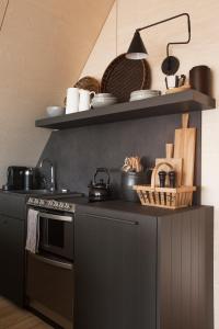 a kitchen with a stove and a shelf with pots and pans at Barn house by the sea in Stokkseyri