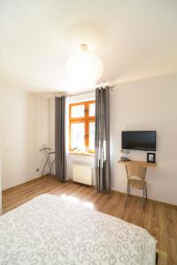 Un dormitorio con una cama y un televisor y una ventana. en Old Town Szczecin, en Szczecin