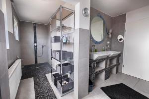 ein Bad mit einem Waschbecken und einem Spiegel in der Unterkunft Pension Weinsberger Tal in Löwenstein