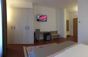 um quarto com uma cama, um armário e uma secretária em Hotel Le Mura e Residence em Città di Castello