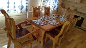 a wooden table with four chairs and a dining room at Pod Modrzewiami in Ciche