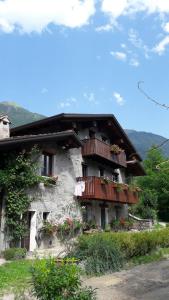 een gebouw met balkons en bloemen erop bij La Via Camuna in Malonno