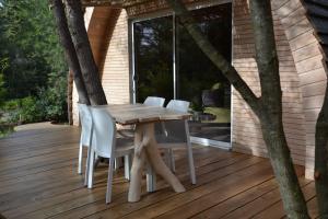 einen Holztisch und Stühle auf einer Terrasse in der Unterkunft Cabanons Jour & Nuit in Mazan