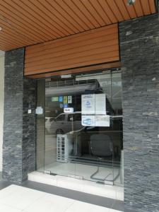 a glass storefront with a car parked in a parking lot at Hotel Sadong88 in Kota Kinabalu
