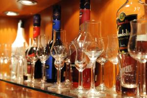 Gizella Hotel and Restaurant في فيسبرم: مجموعة من زجاجات النبيذ وكؤوس النبيذ على منضدة
