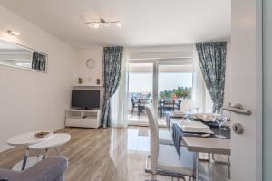 a dining room and living room with a table and chairs at Apartments with pool Villa Zora in Novalja