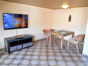 sala de estar con mesa y TV de pantalla plana en Cologne Homestay en Colonia