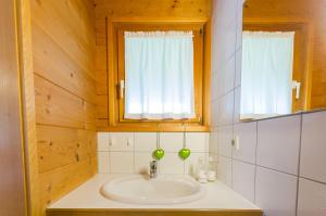a bathroom with a sink and two windows at Appartement Ubelher in Mellau +6 photos