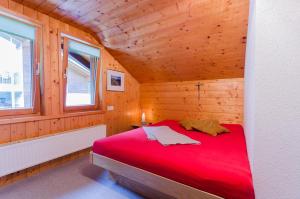メラウにあるAppartement Ubelherの木造キャビンの赤いベッド1台が備わるベッドルーム1室です。