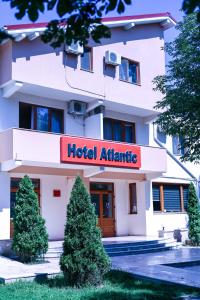 a hotel atenna building with trees in front of it at Hotel Atlantic in Adjud