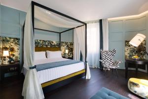 una camera da letto con letto a baldacchino e scrivania di Stendhal Luxury Suites a Roma