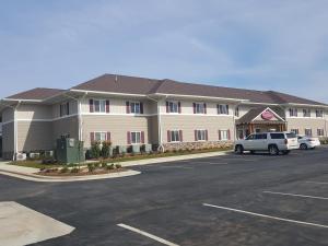 a large building with a parking lot in front of it at Affordable Suites Mooresville in Mooresville