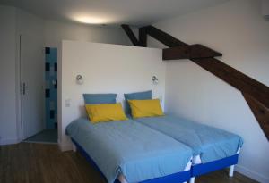 - une chambre avec un lit doté de draps bleus et d'oreillers jaunes dans l'établissement Art Home, à Carcassonne