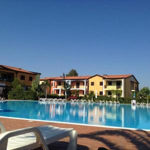 a large swimming pool with chairs and a building at Case Vacanza Villaggio Riva Azzurra in Policoro