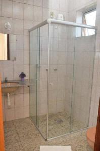 a shower with a glass door in a bathroom at Hotel Alvorada I in Sete Lagoas