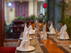 a table with wine glasses and a rose on it at Sapa Centre Hotel in Sapa