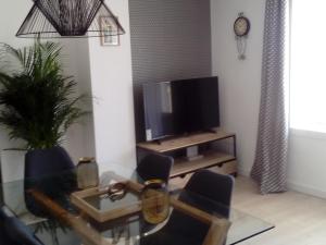 ein Wohnzimmer mit einem TV und einem Tisch in der Unterkunft ConMdeMálaga San Millán Centro in Málaga