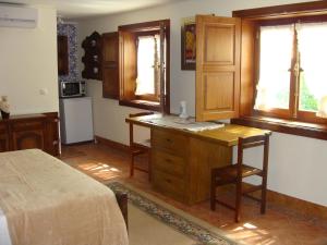 a kitchen with a wooden desk and a table at Solar da Salvadoura in Amares