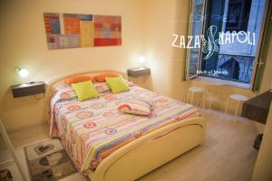 ナポリにあるCasetta Zazàのベッドルーム1室(カラフルな掛け布団付きのベッド1台付)