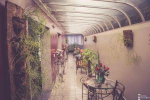 a hallway with tables and chairs and plants in a building at Jardim Hotel in São Bernardo do Campo