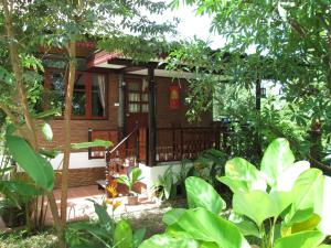 una casa en medio de un jardín en Happiness Resort Sukhothai, en Sukhothai