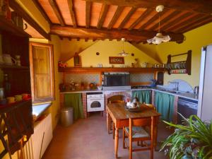 cocina con mesa de madera y fogones en Independent Tuscan Holiday Home with Garden and Valley views, en Pieve Fosciana