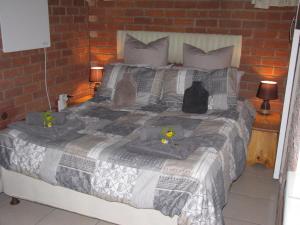 a bed with two cats sitting on top of it at Amani Guest house Clarens in Clarens