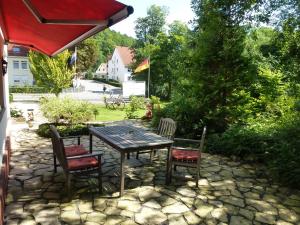 a wooden table and chairs on a stone patio at Hotel Pension Gelpkes Mühle in Bad Sachsa
