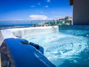 a jacuzzi tub with a view of a city at Maritim Antonine Hotel & Spa in Mellieħa
