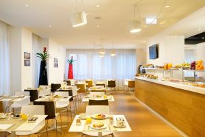 restauracja ze stołami i krzesłami oraz bufetem w obiekcie UNA HOTELS Century Milano w Mediolanie