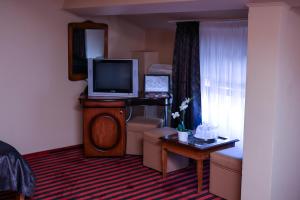 a hotel room with a television and a living room at Hotel Atlantic in Adjud