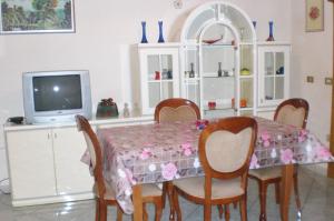 comedor con mesa, sillas y TV en Villino Monte San Michele, en Oria