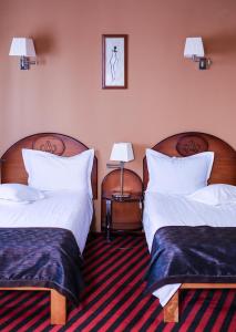 two beds in a hotel room with two lamps at Hotel Atlantic in Adjud +60 photos