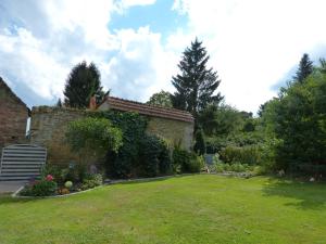 une cour avec une maison en briques et un jardin dans l'établissement La Santijohannaise, à Saint-Jean-Kourtzerode