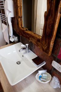 een badkamer met een witte wastafel en een spiegel bij Garnì La Rua nel Bosco in Rivisondoli