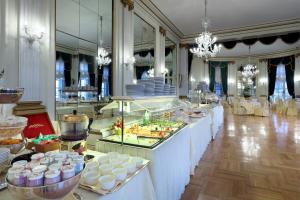 una linea a buffet con cibo in esposizione in una stanza di Eurostars Hotel Excelsior a Napoli