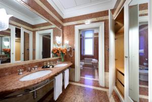 a bathroom with two sinks and a large mirror at Eurostars Hotel Excelsior in Naples