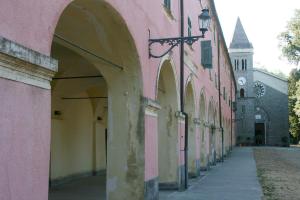 an alley with pink and yellow buildings and a church at Santuario NS Soviore Cinque Terre in Monterosso al Mare