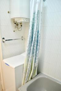 a bathroom with a shower curtain next to a toilet at Feel the Breath of the Ocean in Puerto de Santiago