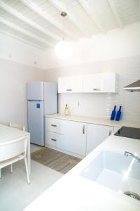 a kitchen with white cabinets and a blue refrigerator at Chora House in Mýkonos City