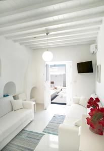 a white living room with white furniture and a tv at Chora House in Mýkonos City
